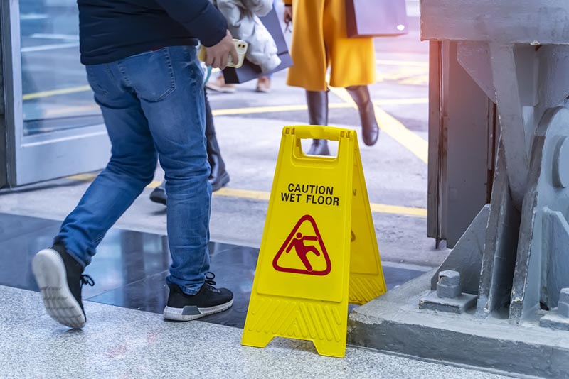 Wet floor sign signaling a slip and fall hazard needing CGL coverage