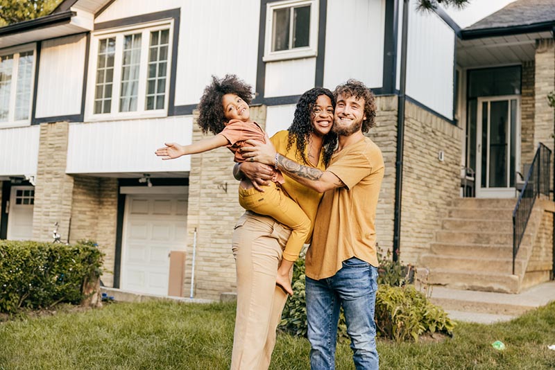 New homeowners celebrate the purchase of their home and plan to protect it with home insurance